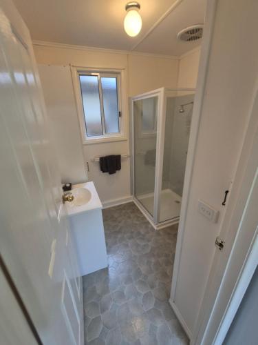 a bathroom with a sink and a shower at Eagle Point Caravan Park in Eagle Point