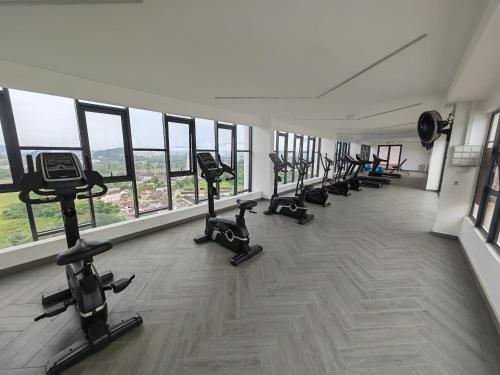 a gym with a row of treadmills and exercise bikes at Decozy7.0 Ipoh Town Condo(12pax) in Ipoh