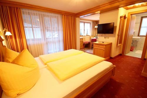 a hotel room with a bed and a television at Appartement Landhaus Jehle in Flirsch