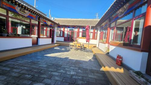 a patio of a building with a table and chairs at 古北御尚精品民宿Gubeiyushang in Gubeikou