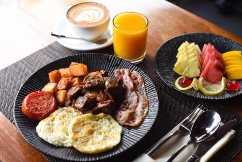 Una mesa con dos platos de desayuno y una taza de café. en Yushili Hotel Kampala, en Kampala