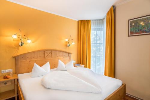 a bedroom with a white bed and a window at POP-UP LIVING Zell am See in Zell am See