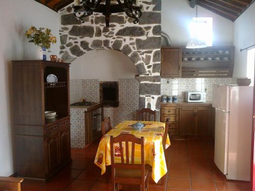 a kitchen with a table and a stone wall at Casas do Monte Alegre in Nordestinho