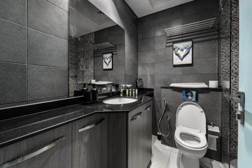 a bathroom with a toilet and a sink at Izzzi Life Mint in Dubai
