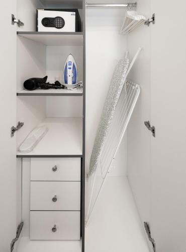 a closet with white cabinets and a shelf at Izzzi Life Mint in Dubai