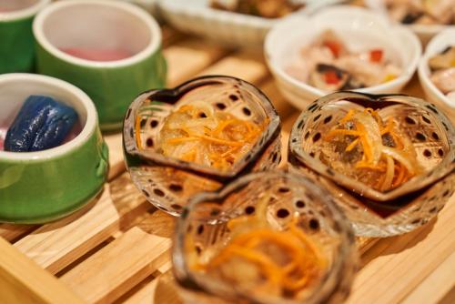 深谷市にある埼玉グランドホテル深谷の木のテーブルの上に置かれたたくさんの食べ物の入ったボウル
