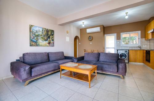 a living room with two purple couches and a table at Private Room in shared apartment in Paphos