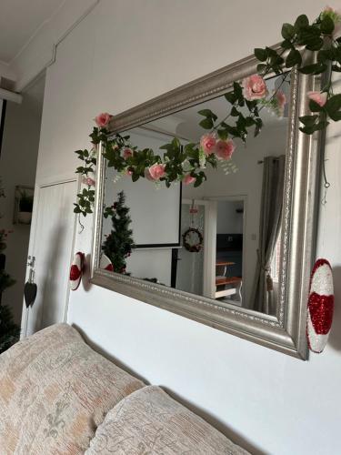 a mirror on a wall with pink flowers on it at Beautiful home in central Bishop Auckland town in Bishop Auckland