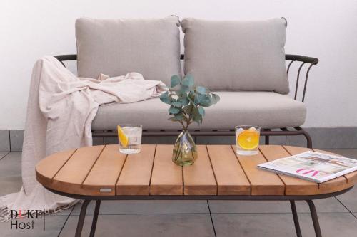 a coffee table with a couch and a vase of flowers on it at Duke 5torres Apartments in Madrid