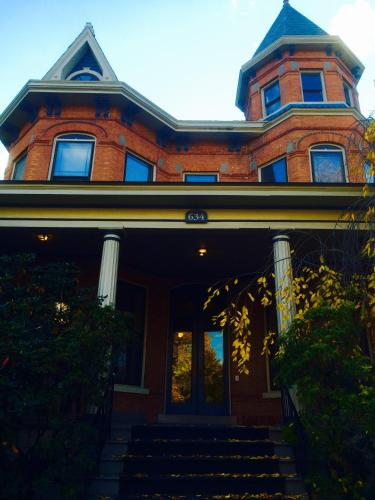 a red brick house with stairs in front of it at Washington Park Inn in Albany