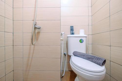 une salle de bain avec toilettes et douche dans l'établissement Comfort Living Studio at Margonda Residence 5 Apartment By Travelio, à Depok