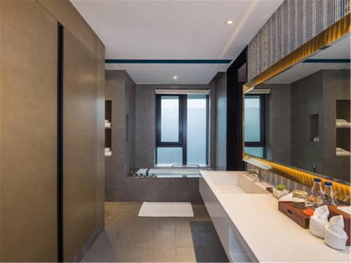 baño con 2 lavabos y espejo grande en MiniMax Premier Hotel Shanghai Hongqiao, en Shanghái