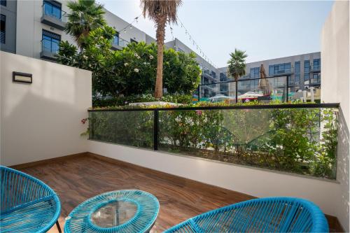 a balcony with blue chairs and a view of a city at Izzzi Life Mint in Dubai