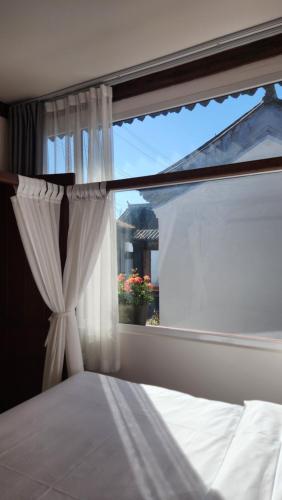 a bedroom with a window with a white curtain at 古北御尚精品民宿Gubeiyushang in Gubeikou