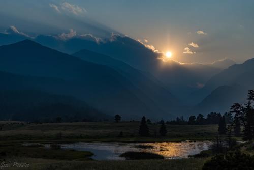 un coucher de soleil sur une chaîne de montagnes avec une rivière dans l'établissement Elk Haven, à Estes Park