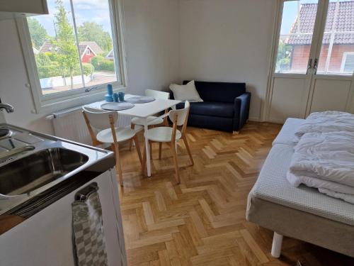 a kitchen with a table and chairs and a couch at Central enrums lägenhet med altan in Falkenberg