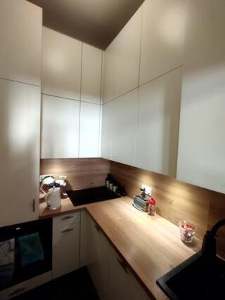 une cuisine avec des armoires blanches et un comptoir en bois dans l'établissement Appartement Hotel du Chastenoy - Vieille ville Stanislas, à Nancy