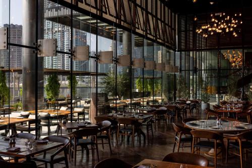 a restaurant with tables and chairs and large windows at The St. Regis Downtown Dubai in Dubai