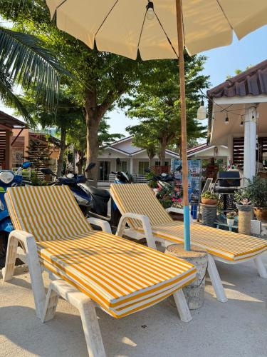 two lounge chairs under an umbrella on a patio at Rang Noknoy Resort at Kohlarn in Ko Larn
