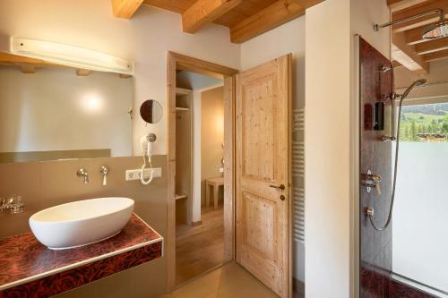 a bathroom with a sink and a shower at Dolomit Boutique Hotel in La Villa
