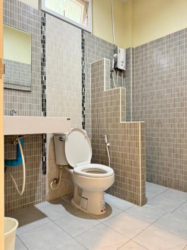 a bathroom with a toilet with a sink and a mirror at Rang Noknoy Resort at Kohlarn in Ko Larn