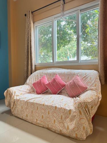a couch with pillows in front of a window at Rang Noknoy Resort at Kohlarn in Ko Larn