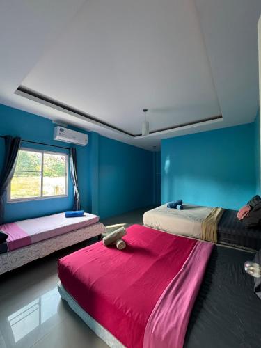 two beds in a room with blue walls at Rang Noknoy Resort at Kohlarn in Ko Larn