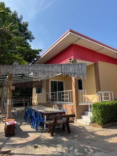 a picnic table and chairs in front of a house at Rang Noknoy Resort at Kohlarn in Ko Larn