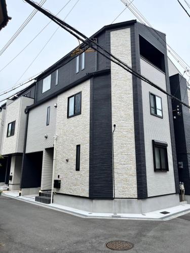 a black and white building on the side of a street at Casa Stella 9 by Liaison in Osaka