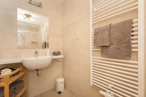 a white bathroom with a sink and a mirror at Ledererhof in Aschau