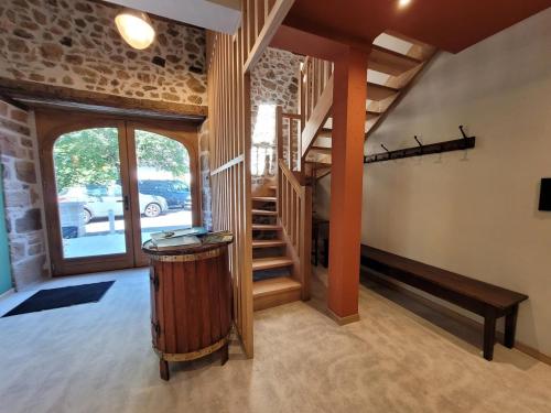 a living room with a staircase and a stair case at Gîte Val Souvigne in Saint-Sylvain