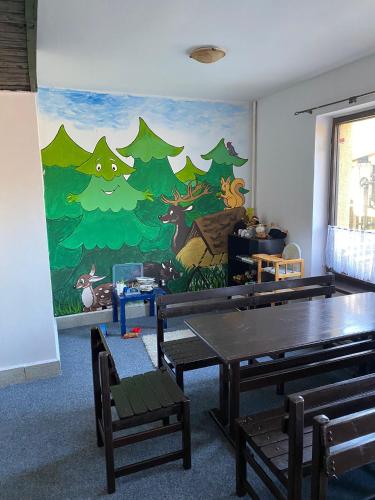 Habitación con una pared con un mural de árboles. en Penzion Krmelec, en Tanvald
