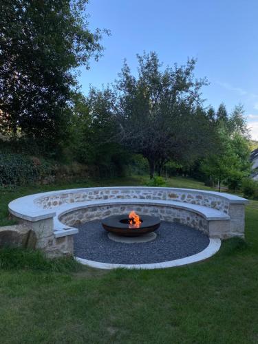 a fire pit in the middle of a yard at Gîte Val Souvigne in Saint-Sylvain
