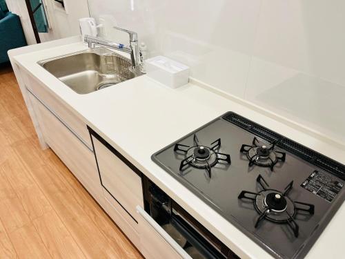 a kitchen with a stove top oven next to a sink at Casa Stella 6 by Liaison in Osaka