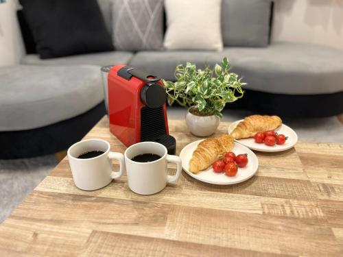 a coffee table with two cups of coffee and croissants at Casa Stella 6 by Liaison in Osaka