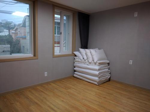 a room with a stack of towels in a room with a window at Backpackers In Yeosu in Yeosu