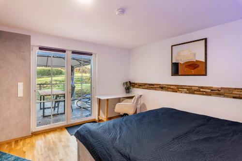 a bedroom with a bed and a desk and a window at Bergisch Resort Helle in Lindlar
