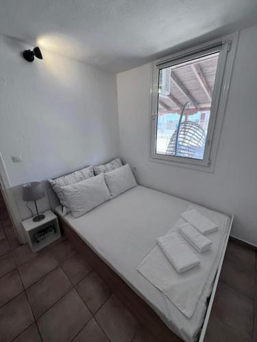 a white bed in a room with a window at Apartment Elpida in Olympiaki Akti