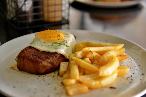 a plate of food with an egg and french fries at SleepOver Lanseria in Lanseria