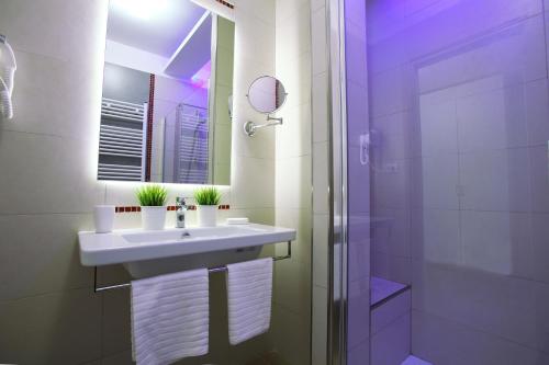 a white bathroom with a sink and a shower at Hotel Cicò in Torre Santa Sabina