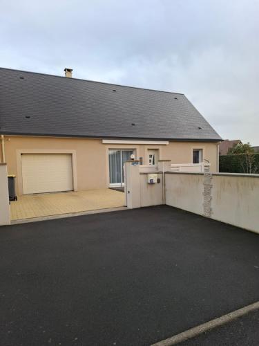 a house with a parking lot in front of it at Le petit coin de Paradis classé 3 étoiles in Hermanville-sur-Mer