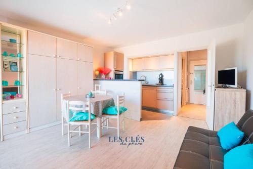 une cuisine et un salon avec une table et des chaises dans l'établissement Le Grand Large Studio face mer, à Le Touquet-Paris-Plage