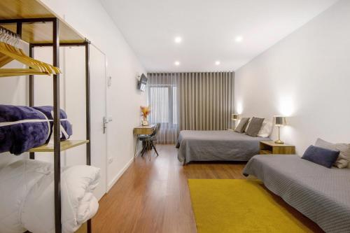 ein Schlafzimmer mit zwei Betten und einem Etagenbett in der Unterkunft Jm Stay Aveiro in Aveiro