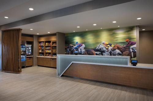 a store lobby with a painting of horses racing at SpringHill Suites by Marriott Bowling Green in Bowling Green