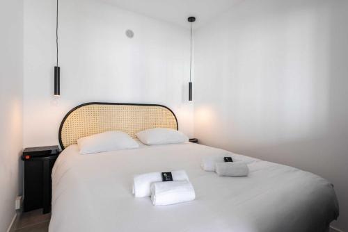 une chambre avec un lit blanc avec des serviettes dessus dans l'établissement Beautiful flat with balcony - 200m from the beach, à Antibes