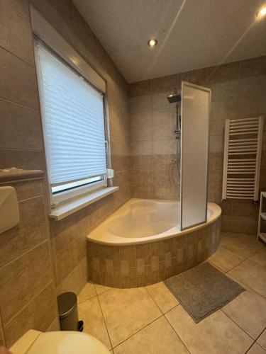 a large bathroom with a tub and a window at NEU! Ferienhaus Sanja in Peickwitz