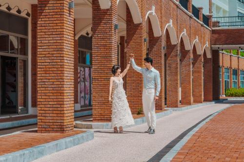 a man and a woman standing in front of a brick building at The Pearl Hoi An in Hoi An