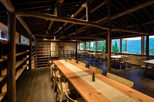 a large room with wooden tables and chairs at 大山初里 Origin Villa Village Hotel&Resort in Tonglu