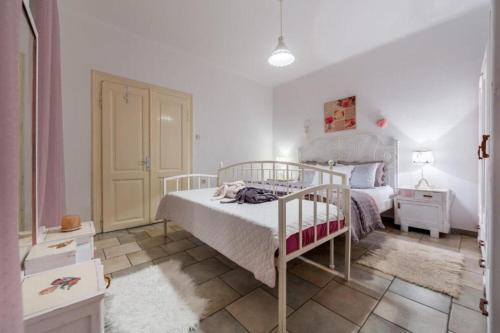 a white bedroom with a bed and a white door at House Ingrid in Rijeka