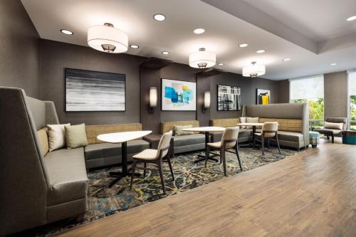 a waiting room with tables and chairs and a couch at Residence Inn by Marriott King of Prussia in King of Prussia